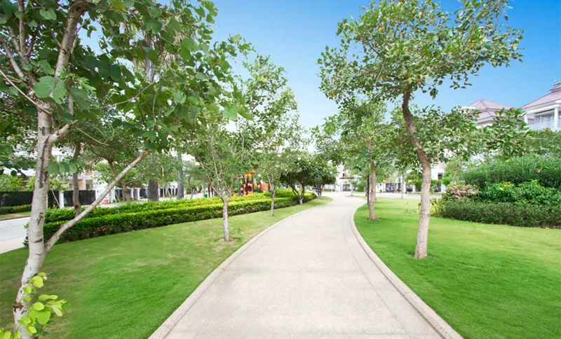 Tree-lined walking path through the central green park at The Star Eternal