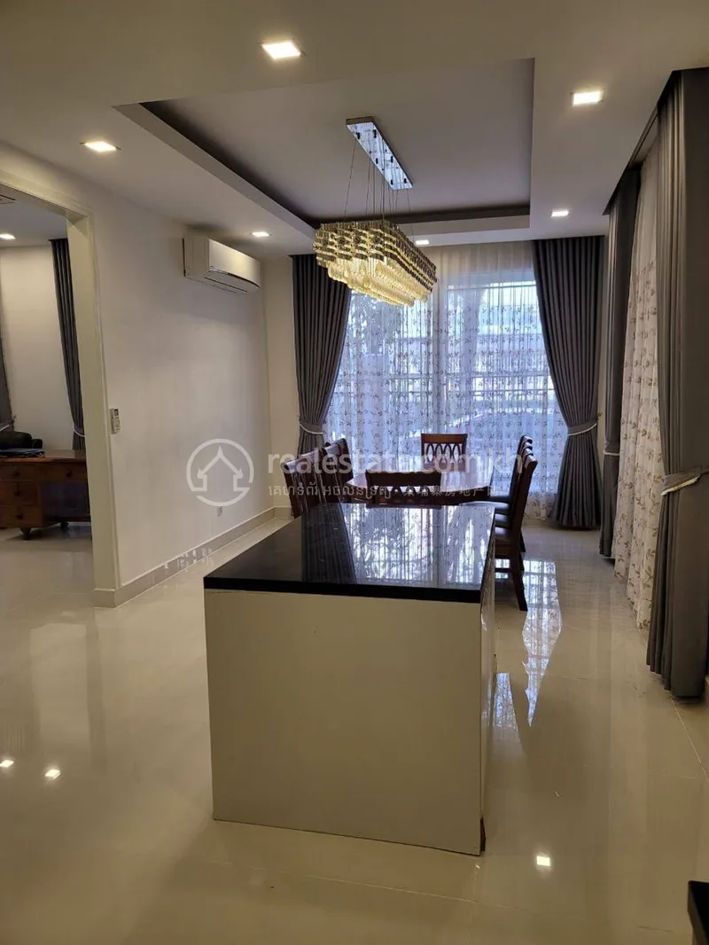 Furnished dining room with chandelier in a Park Land Sen Sok villa