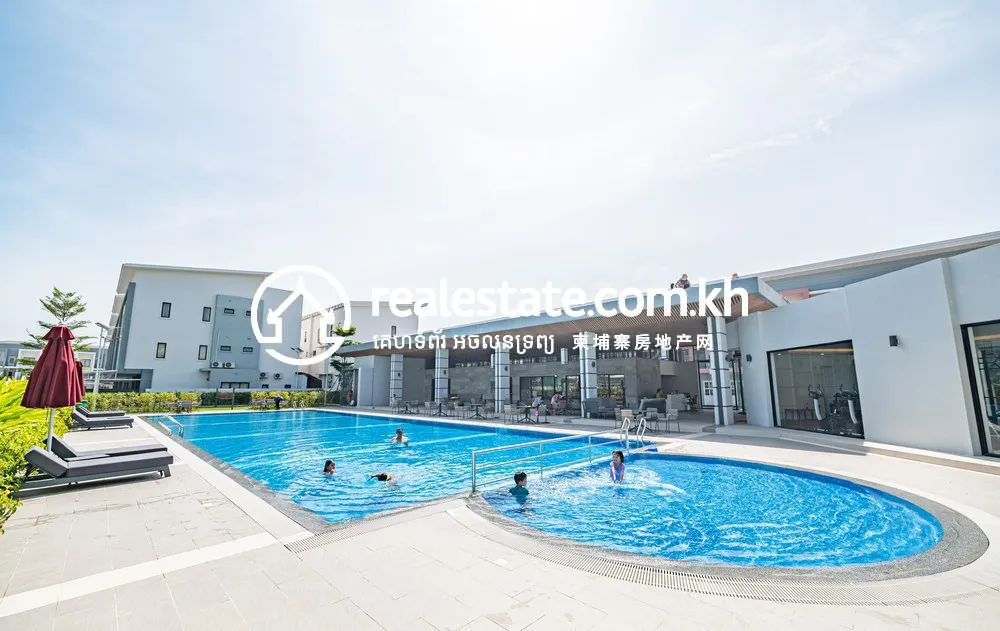 Residents swimming in the ARATA Garden Residences community pool beside the clubhouse