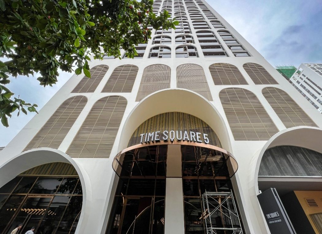 Arched street-level entrance of Time Square 5 (306) with the tower rising above