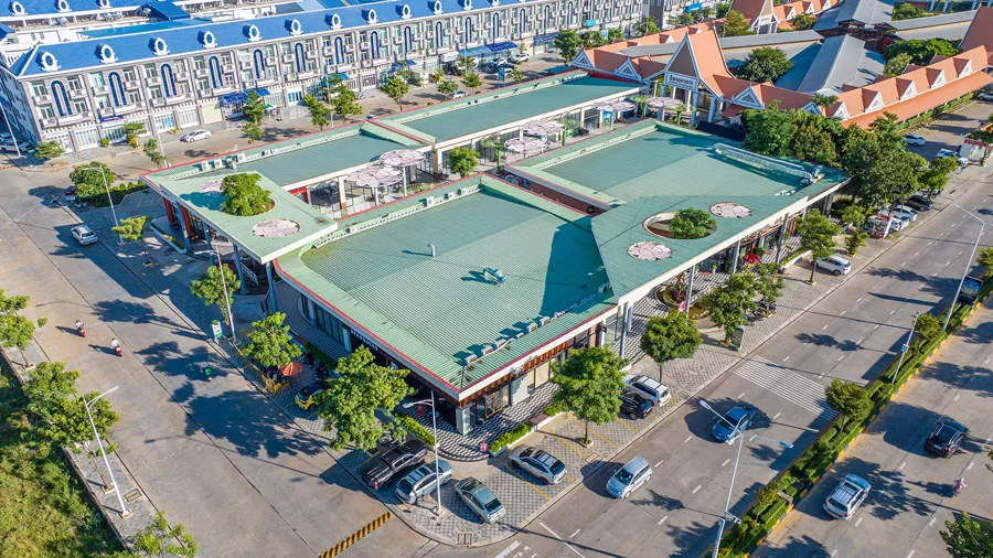 Rows of blue-roofed borey shophouses in a Chroy Changvar housing phase seen from above