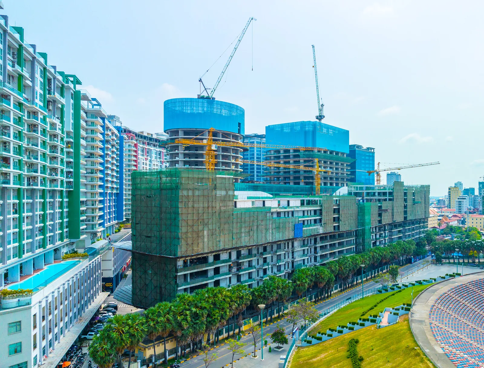 Aerial view of Olympia City under construction with residential towers, mall podium and cranes, central Phnom Penh