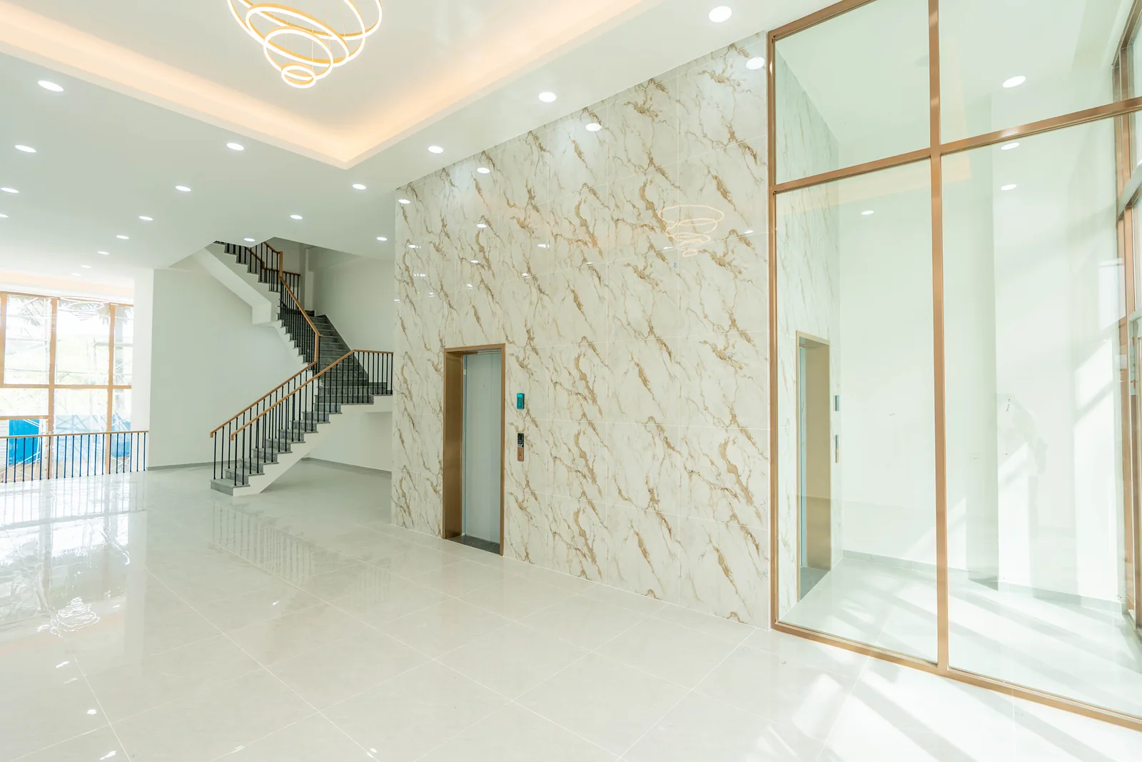 Finished entrance lobby at Olympia City with marble feature wall and glass lift