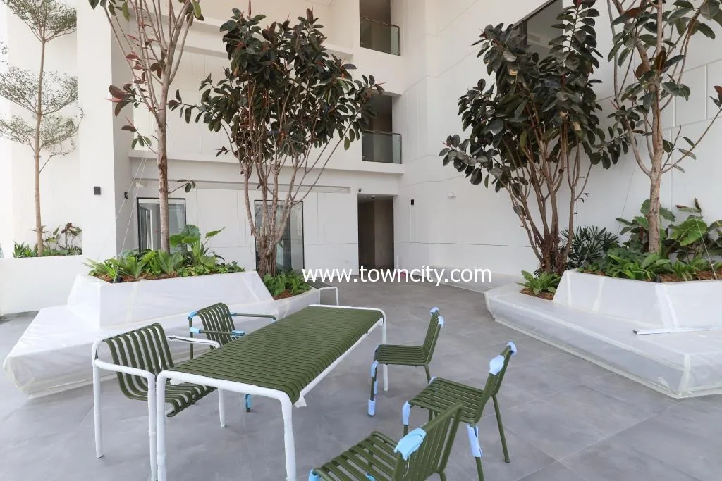 Planted courtyard garden inside Embassy Central with mature trees and seating
