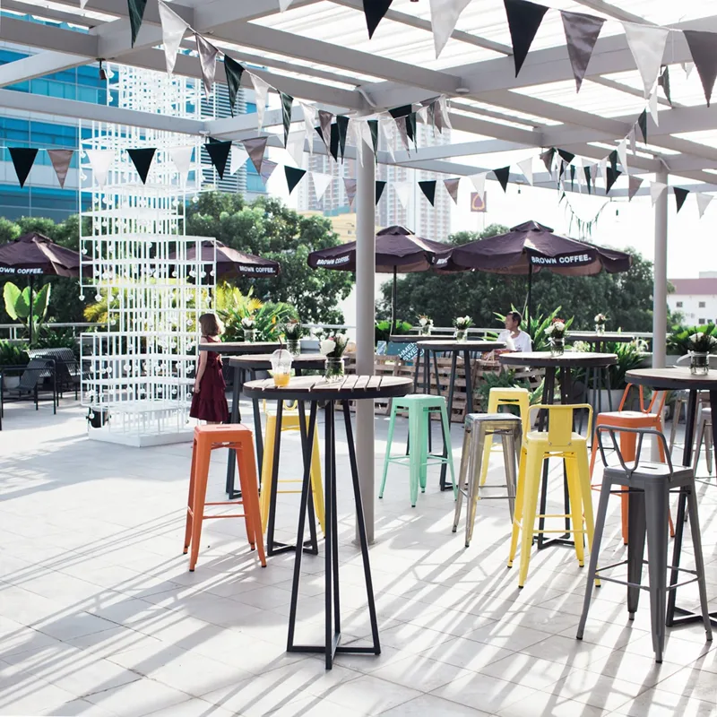 The Crown rooftop terrace at Raintree with colourful stools and city skyline behind