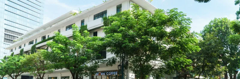 Raintree's corner facade near Wat Phnom, green upper floors above a Brown Coffee at street level